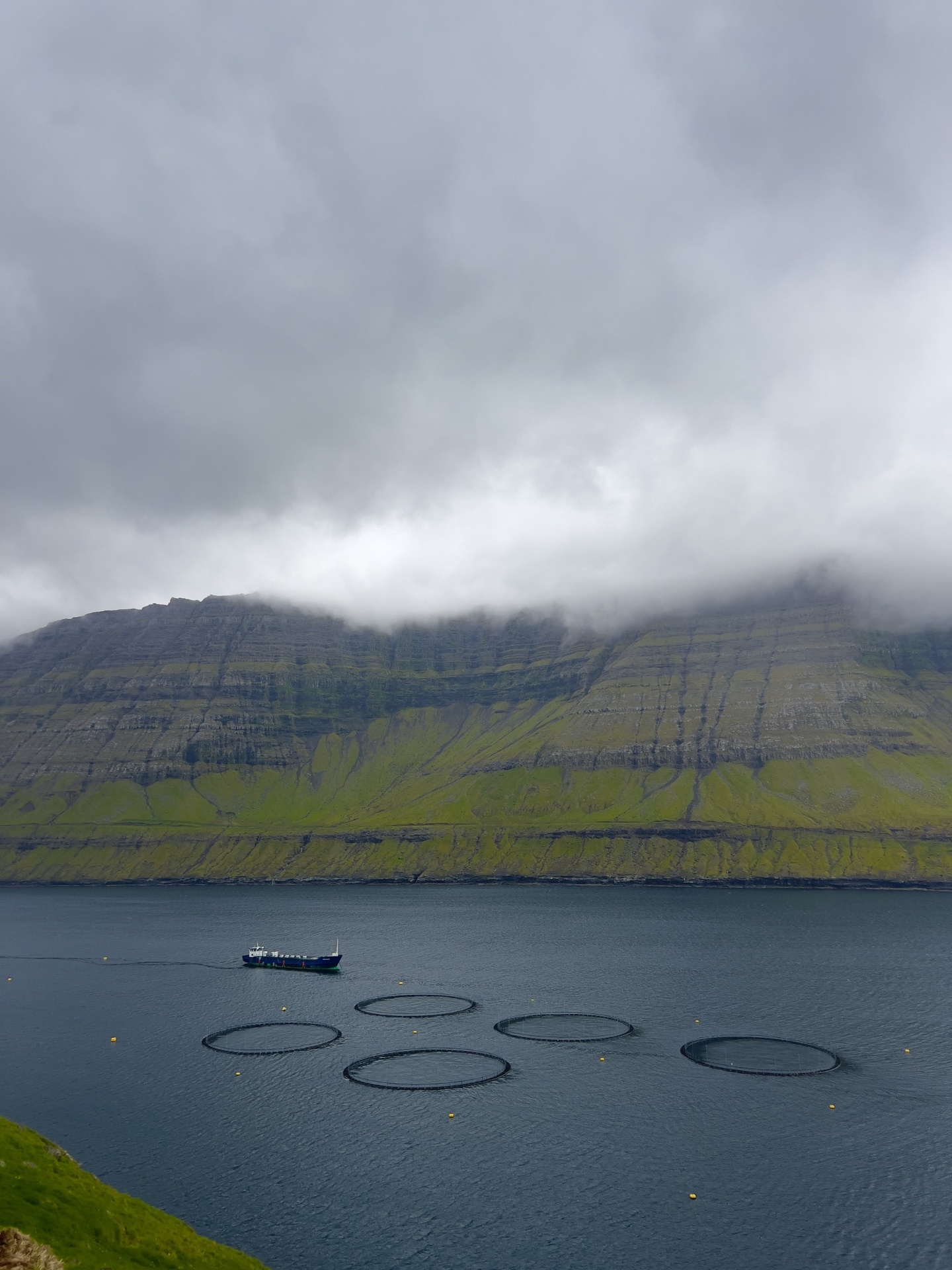 Faroe Islands fish farms with misty mountains